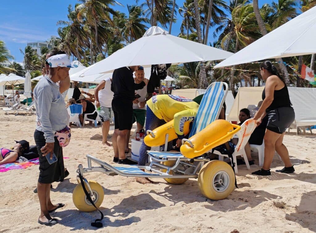 Secretaría de Turismo facilita baño de mar a turista caleña con movilidad reducida con silla anfibia